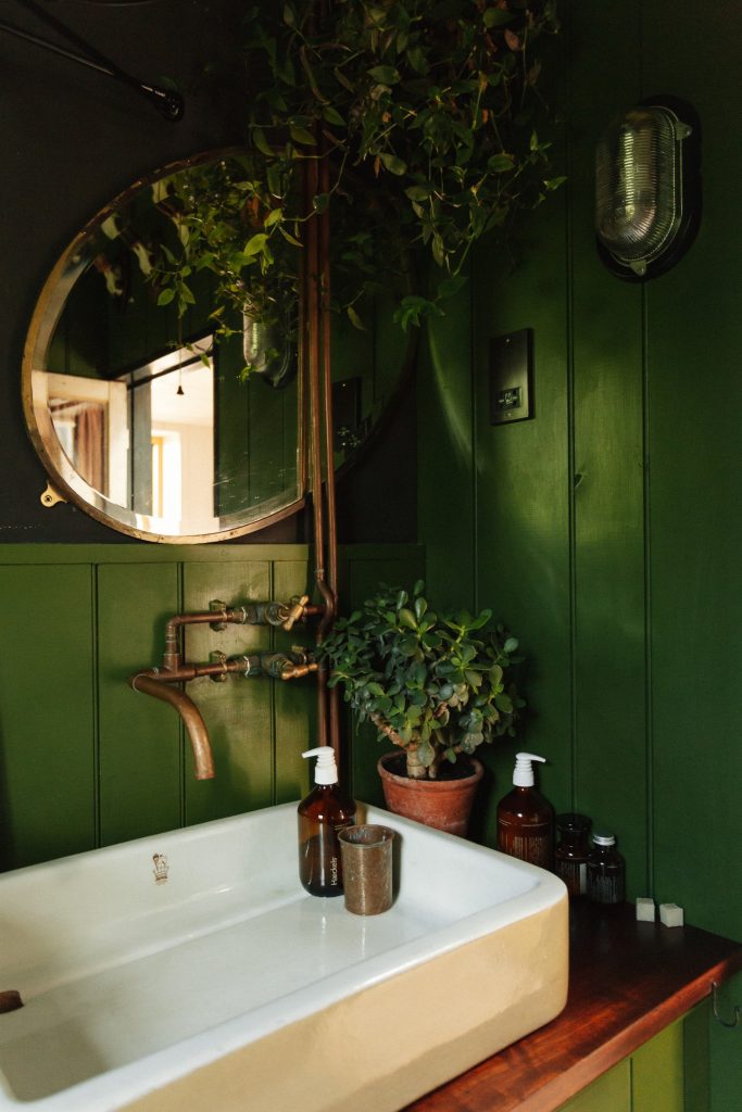 The green-panelled bathroom with a vintage basin