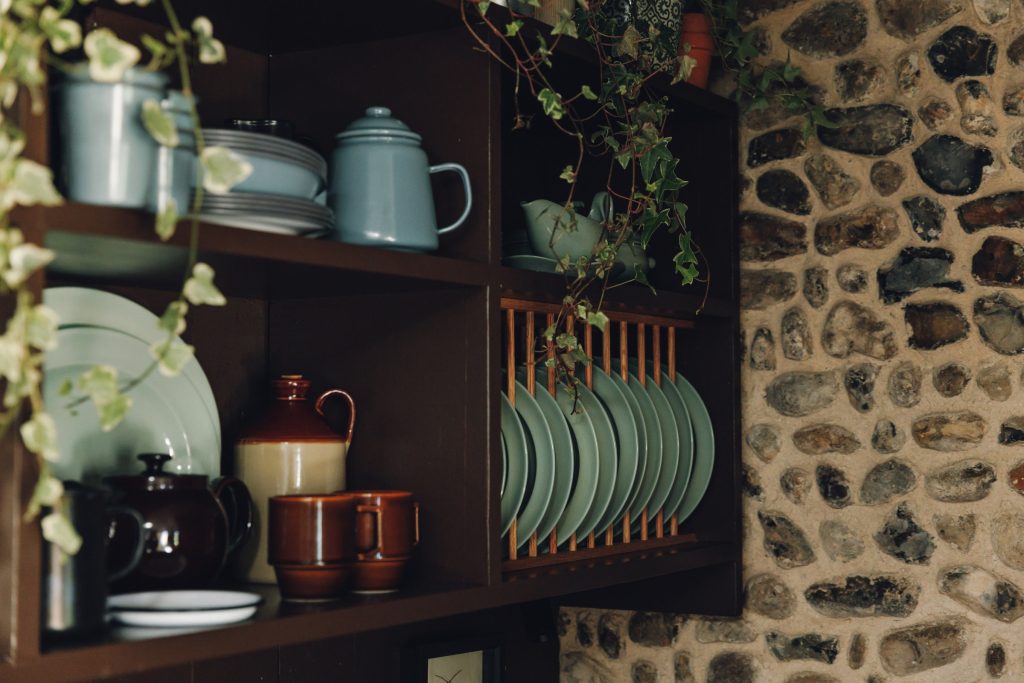 Crockery on open shelves against the flint wall